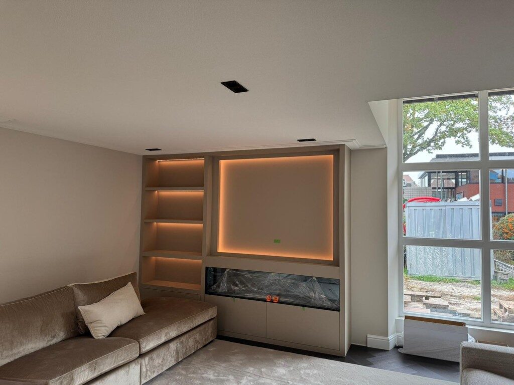 Woonkamer met maatwerk kastwand en geïntegreerde verlichting