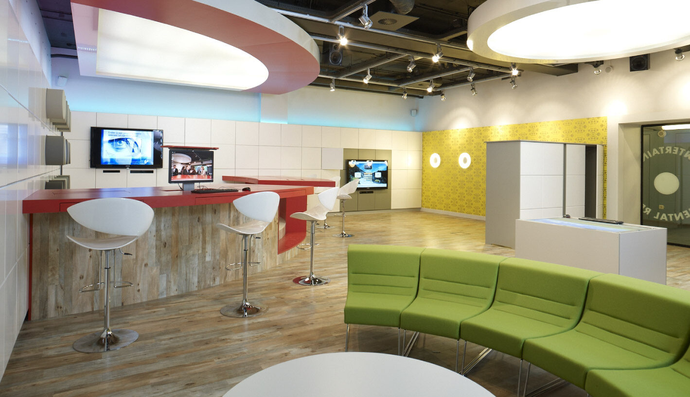 Interieur met maatwerk balie, wandpanelen en zitbank in een presentatieruimte