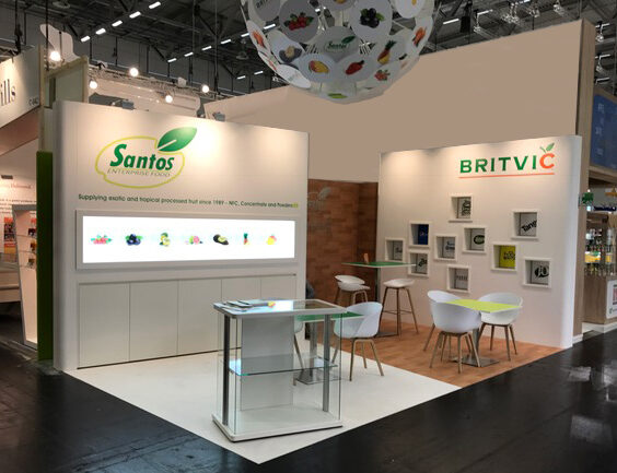 Beursstand van Santos met verlichte productvitrine en zittafels